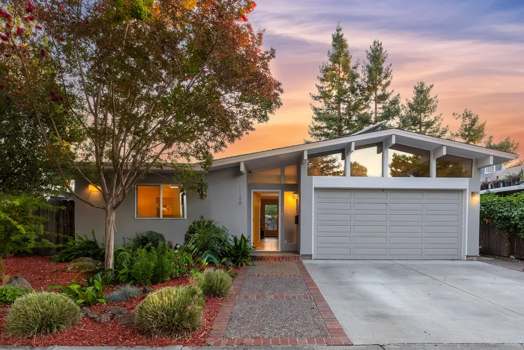 The entry and garage of 1186 Lyons Street at dusk, the open front door showing straight through the house.